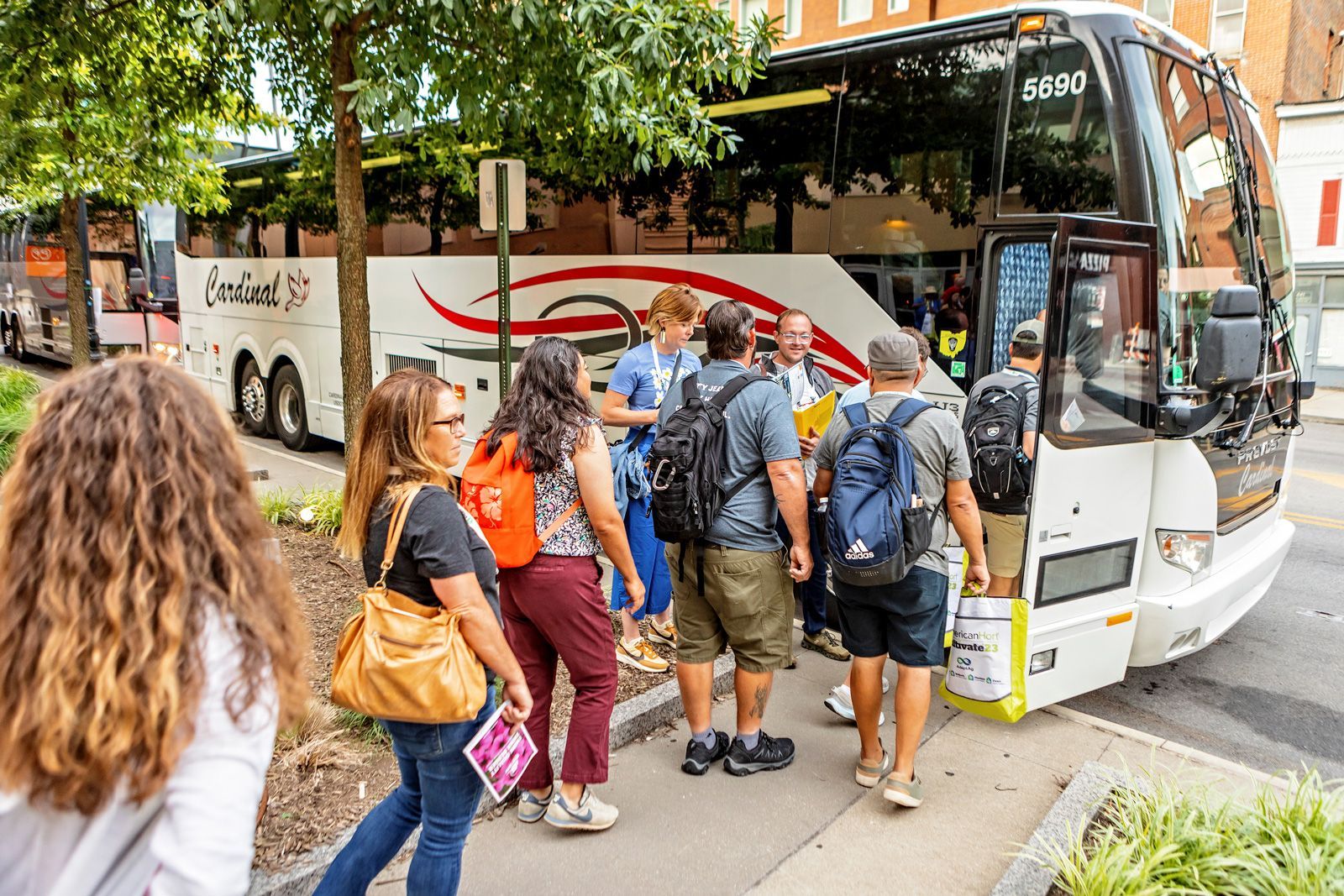 a group of people are boarding a bus on a city street .