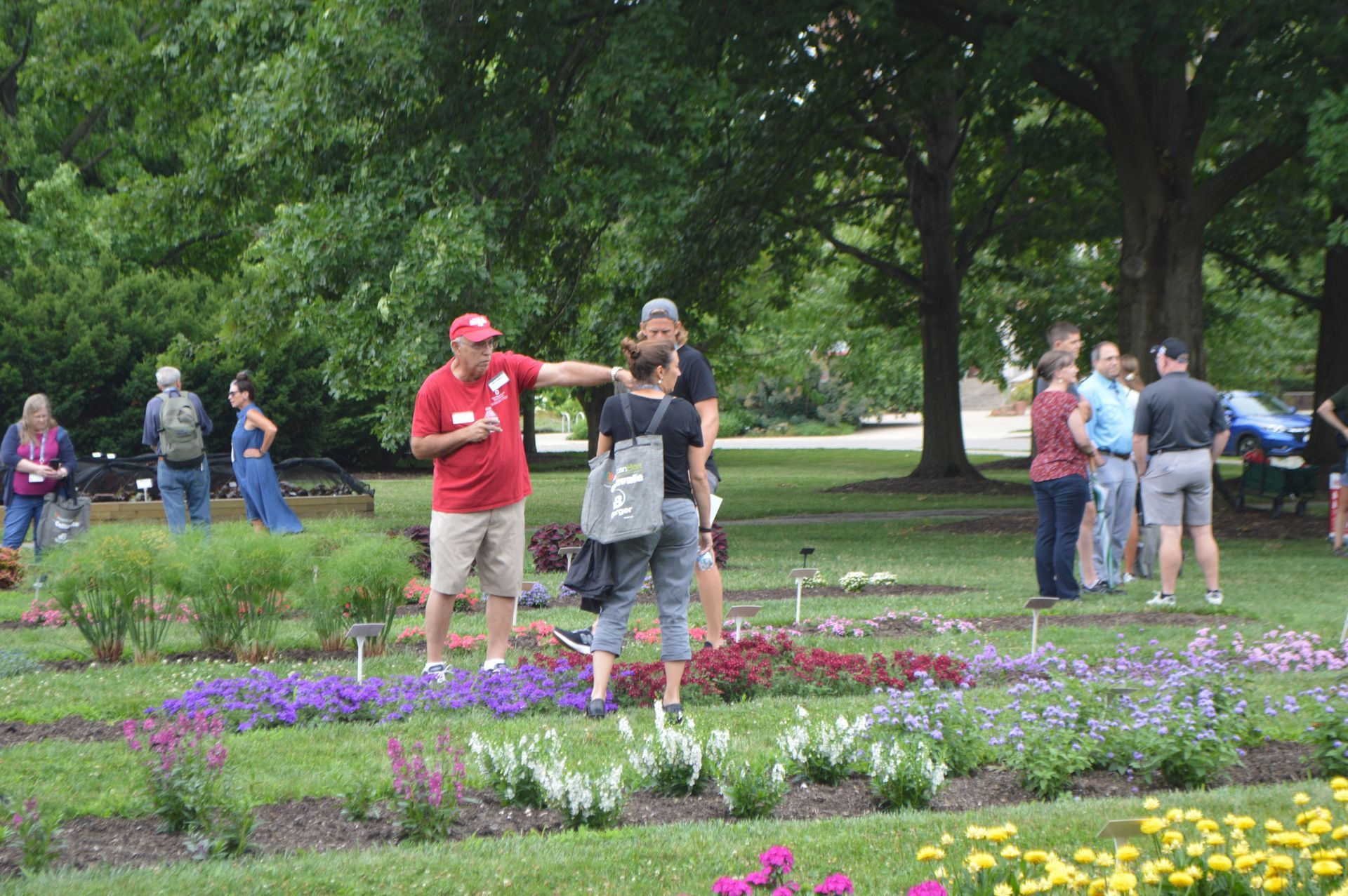 a group of people are standing in a park talking to each other