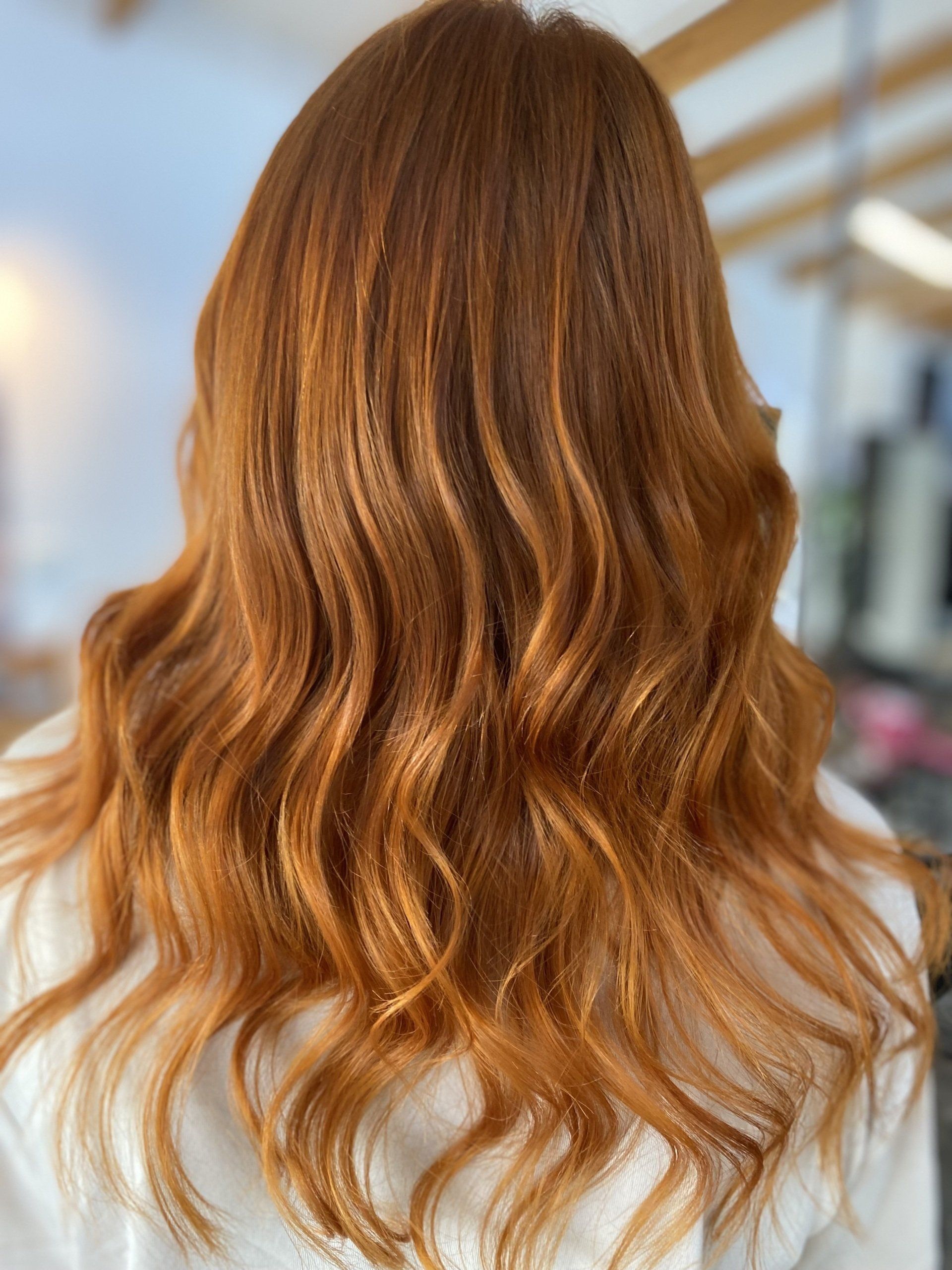 Woman with long, wavy copper-colored hair.