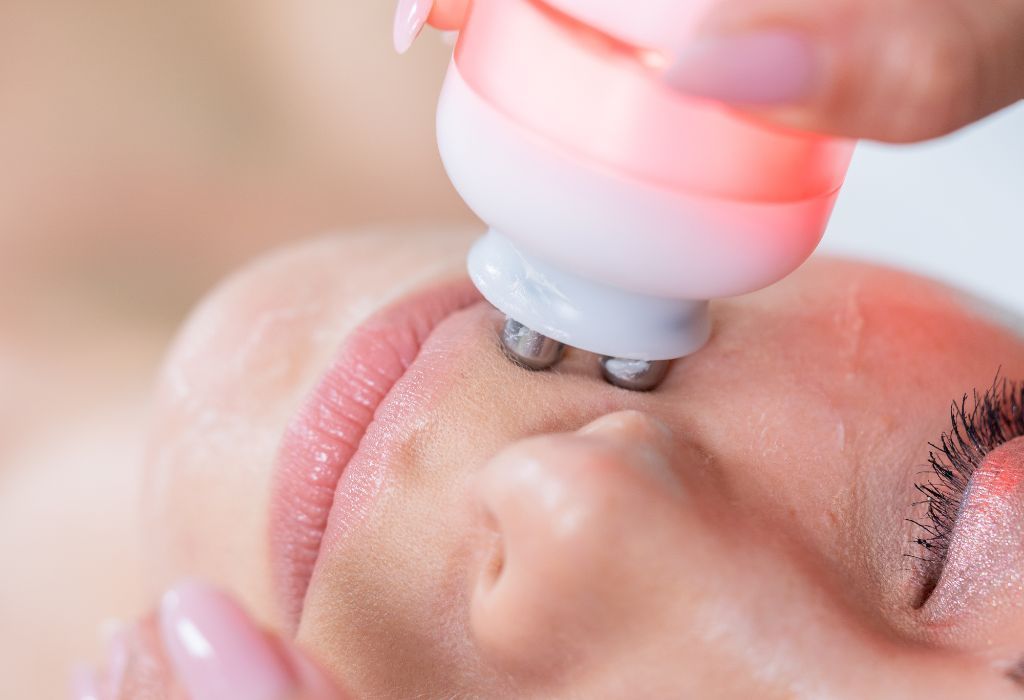 Persona che riceve un trattamento viso con un dispositivo portatile, applicato sulla pelle.