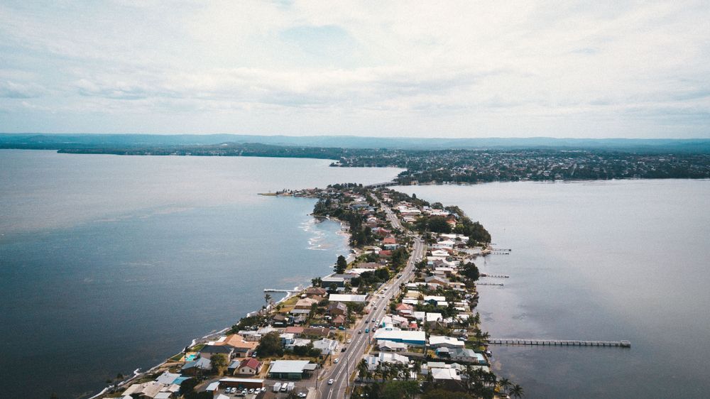 An Aerial View Of A City Next To A Large Body Of Water — Heritage Bricklaying & Remedial Services In Toukley, NSW