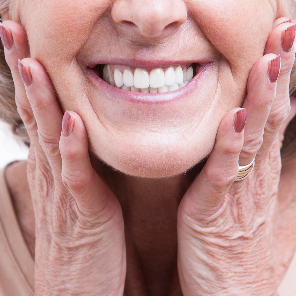 older woman smiling with perfect dentures done by our family dentist in Friendswood TX