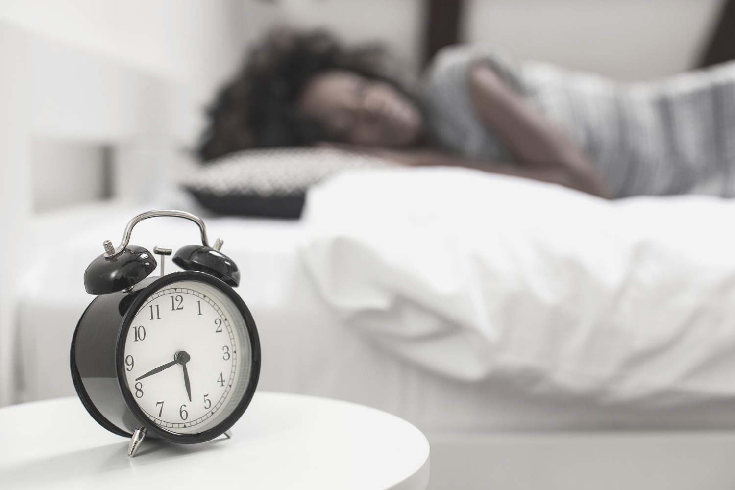woman sleeping next to alarm clock | Get night guards for better sleep | Dentist in Friendswood TX