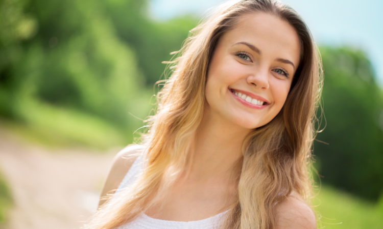 woman smiling after teeth cleaning and whitening services from our dentist in Friendswood TX