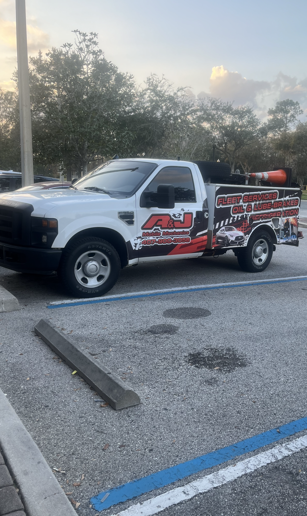 A white tow truck is parked in a parking lot.