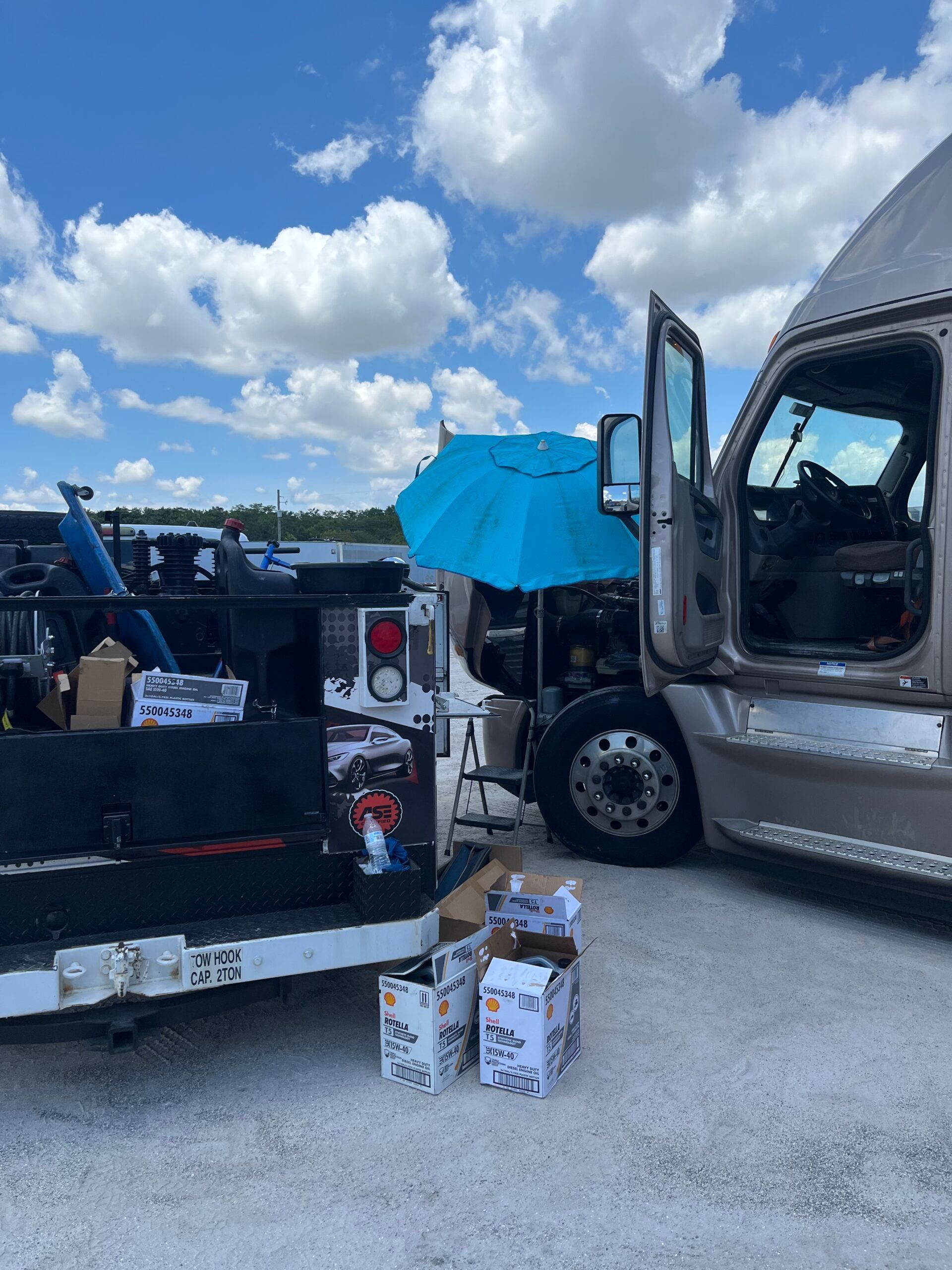 A truck is parked next to a truck with boxes in the back.