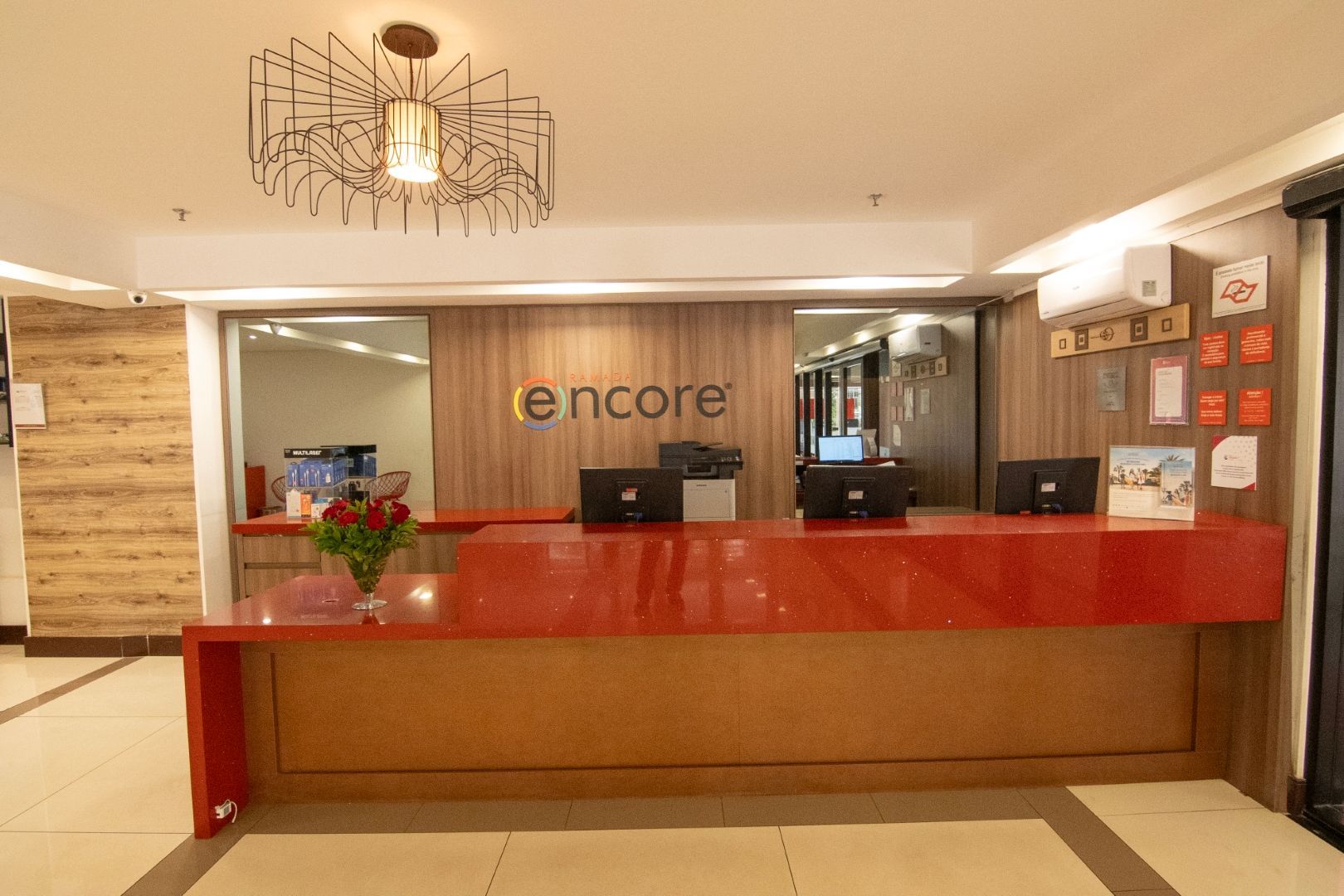 Um lobby de hotel com um balcão vermelho e uma placa que diz encore