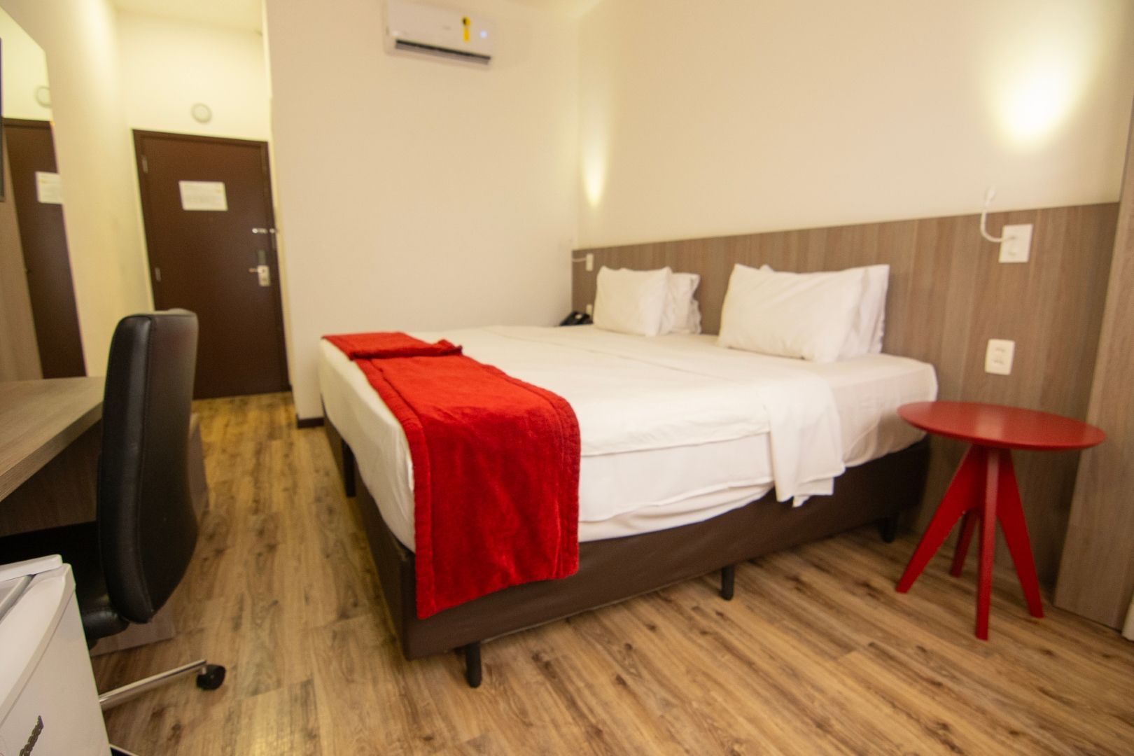 Um quarto de hotel com duas camas, uma escrivaninha e uma cadeira.