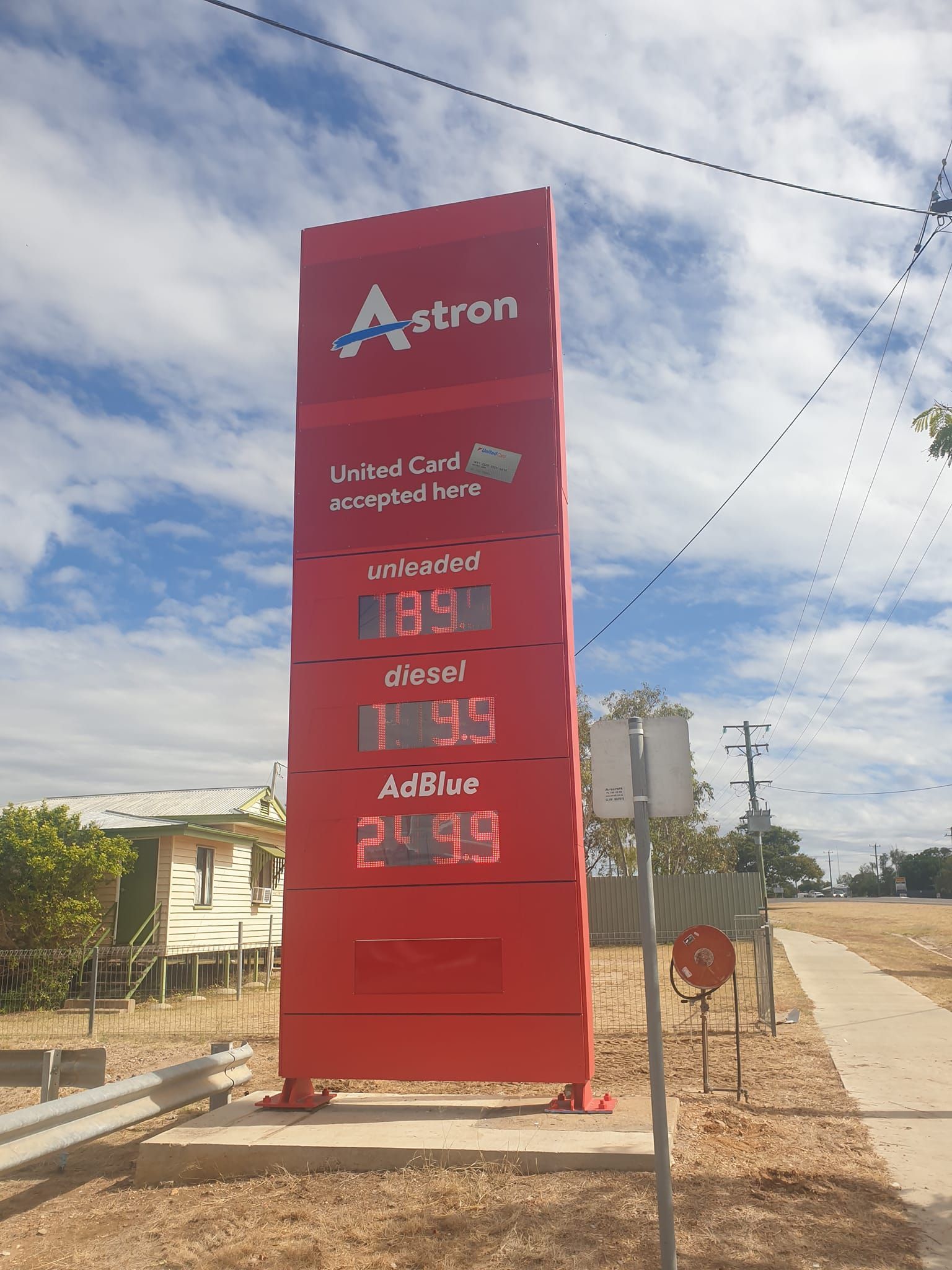 Red Astron gas station sign displaying fuel prices: Unleaded $1.85, Diesel $1.99, AdBlue $2.09.