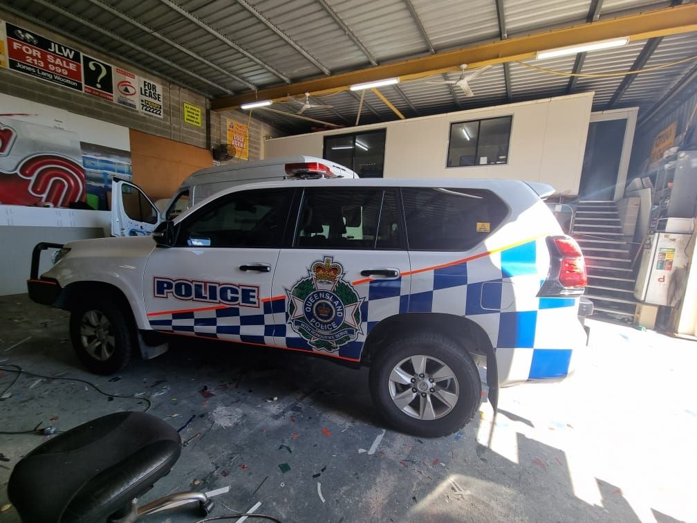 Police SUV inside a garage, with blue and white checkered pattern on the side. 