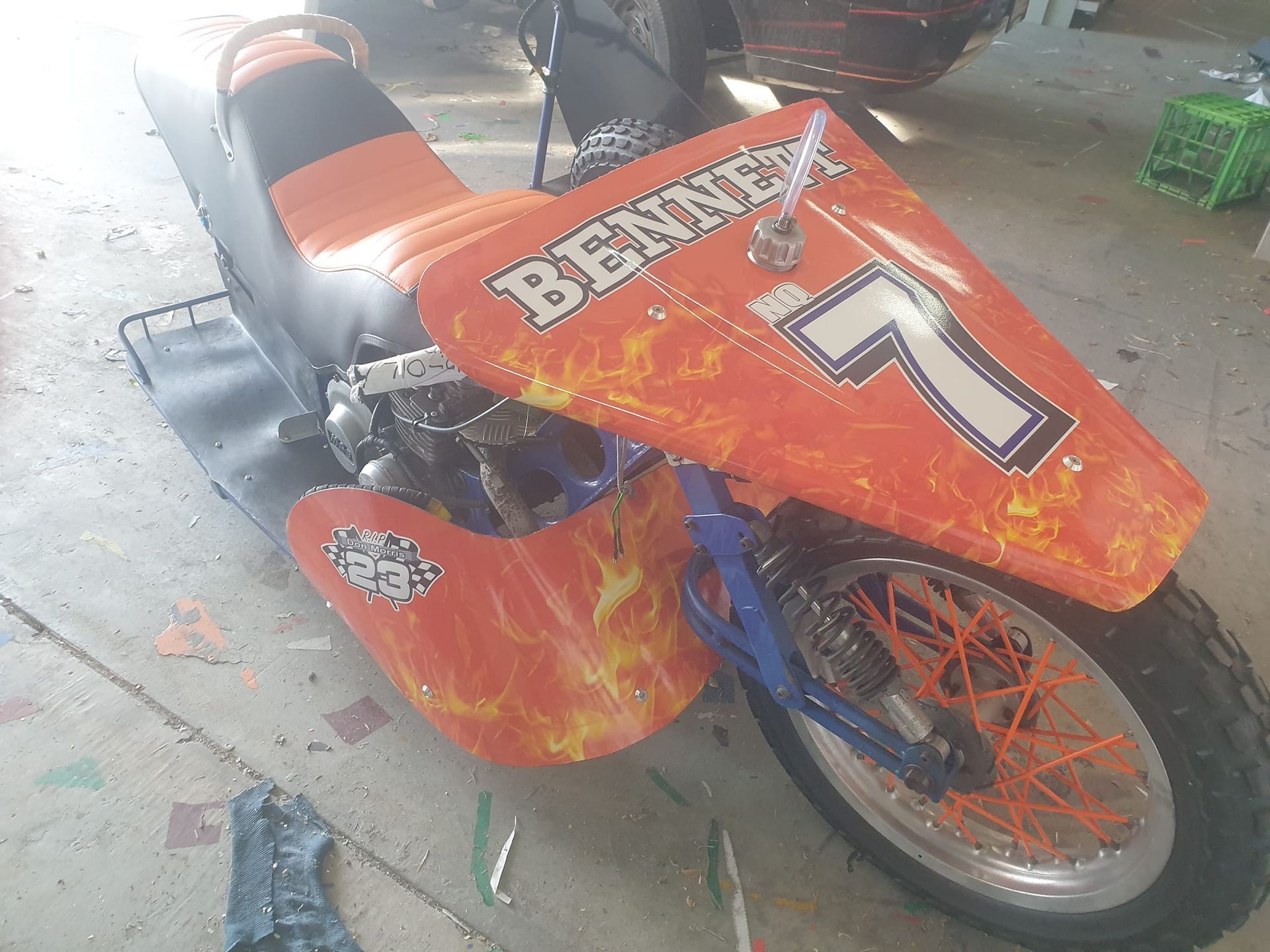 Orange and black custom scooter with flame design and the number 7.