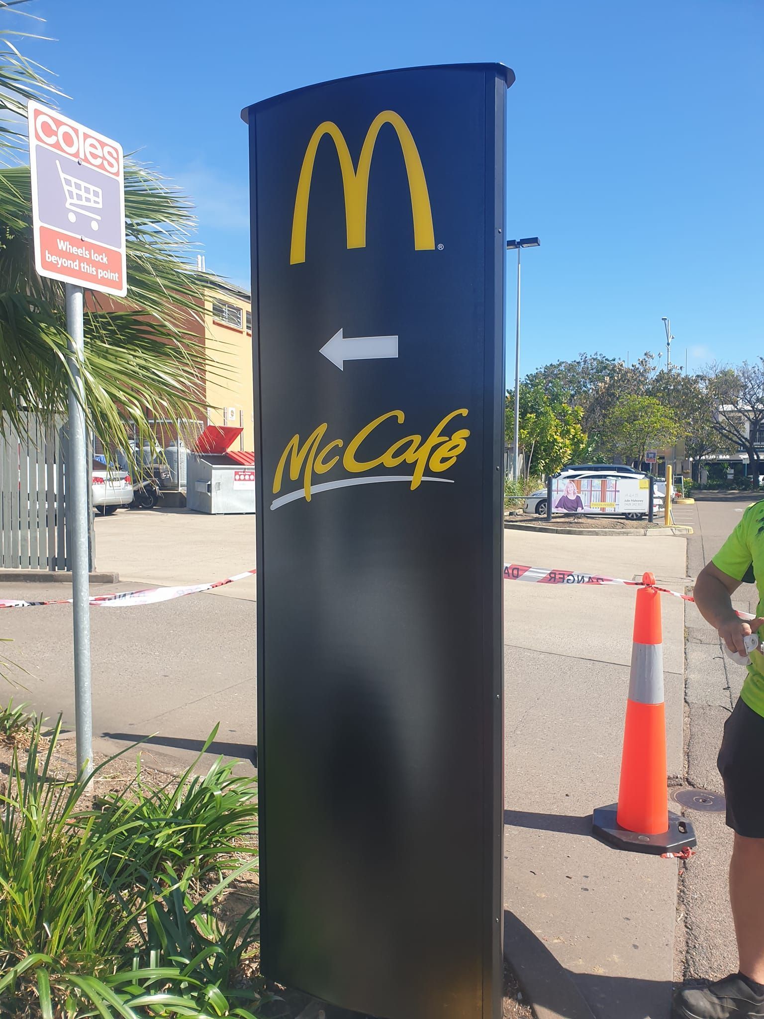 McDonald's sign, black with yellow arches, arrow, and 