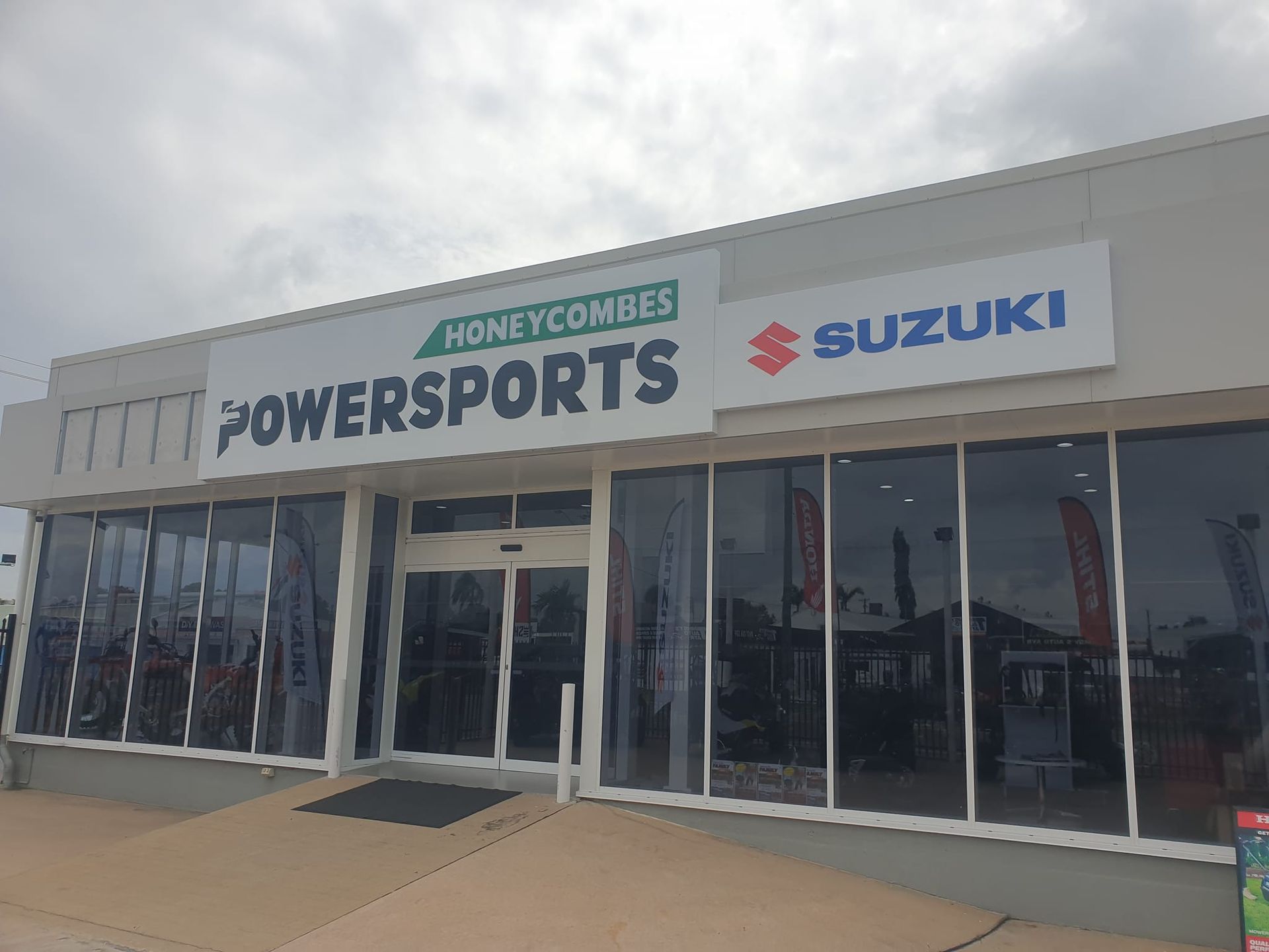 Honeycomb Powersports Suzuki dealership with large glass windows and automatic doors.