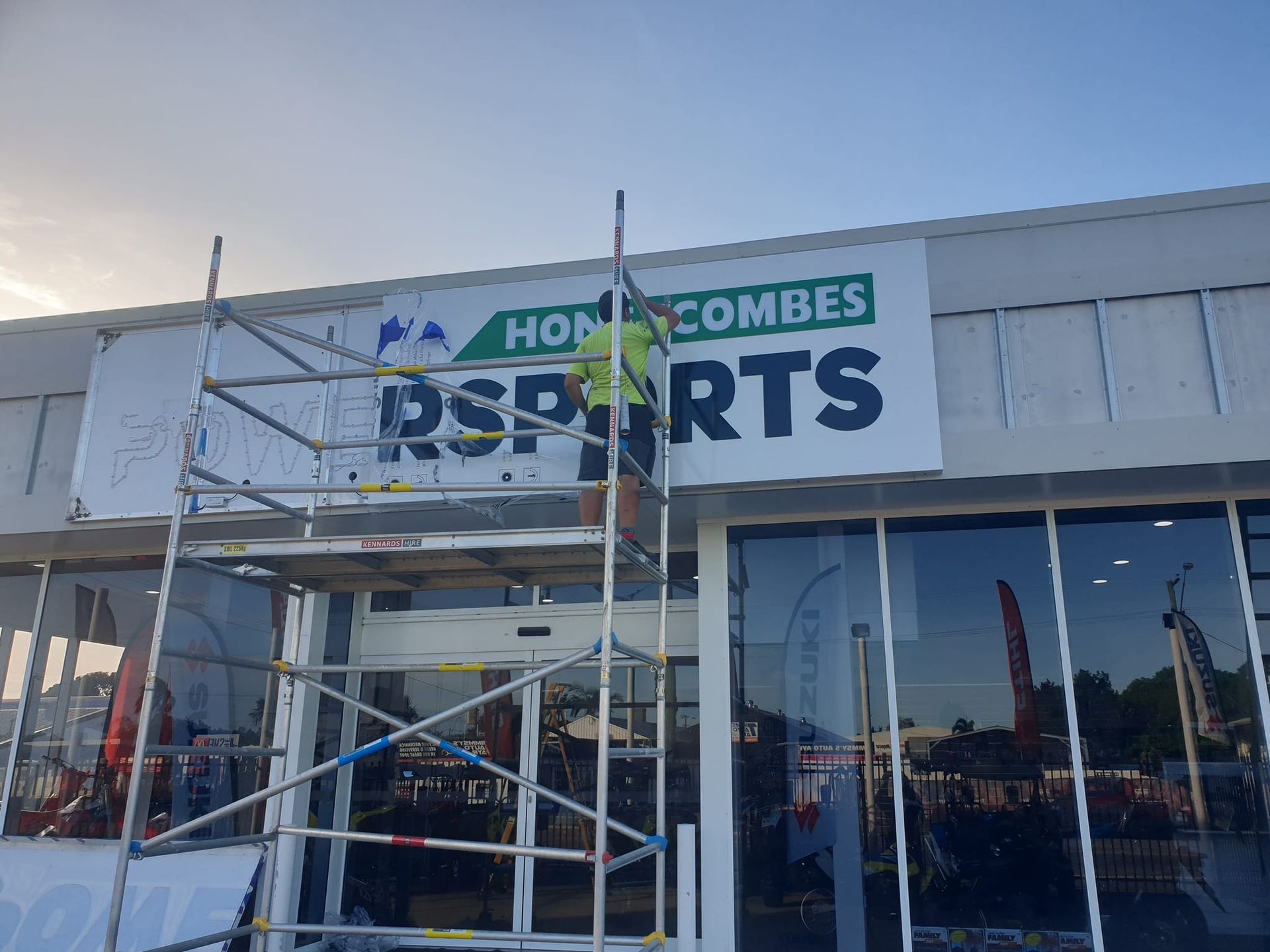 Person on scaffolding installing a sign for 