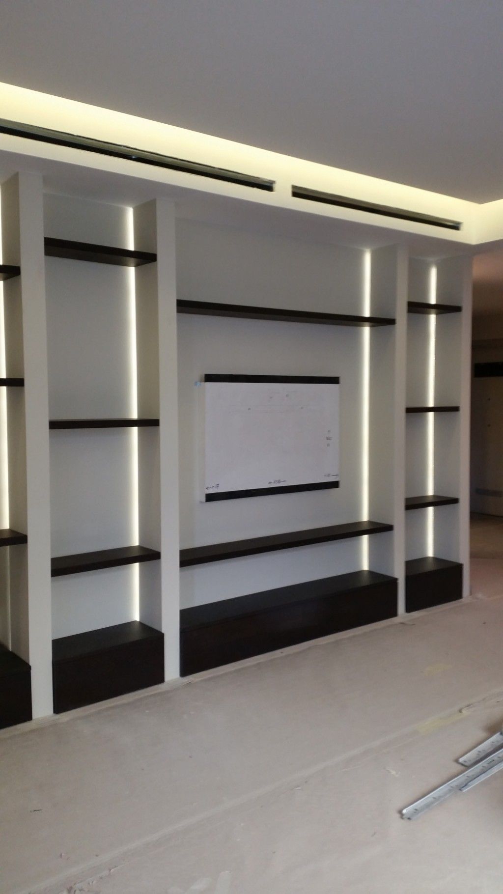 Mobile TV moderno a incasso bianco e nero con ripiani e illuminazione a incasso in una stanza