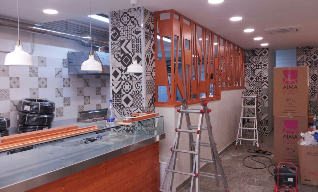 Interni di un ristorante in fase di ristrutturazione, con scale, armadietti e attrezzi da lavoro.