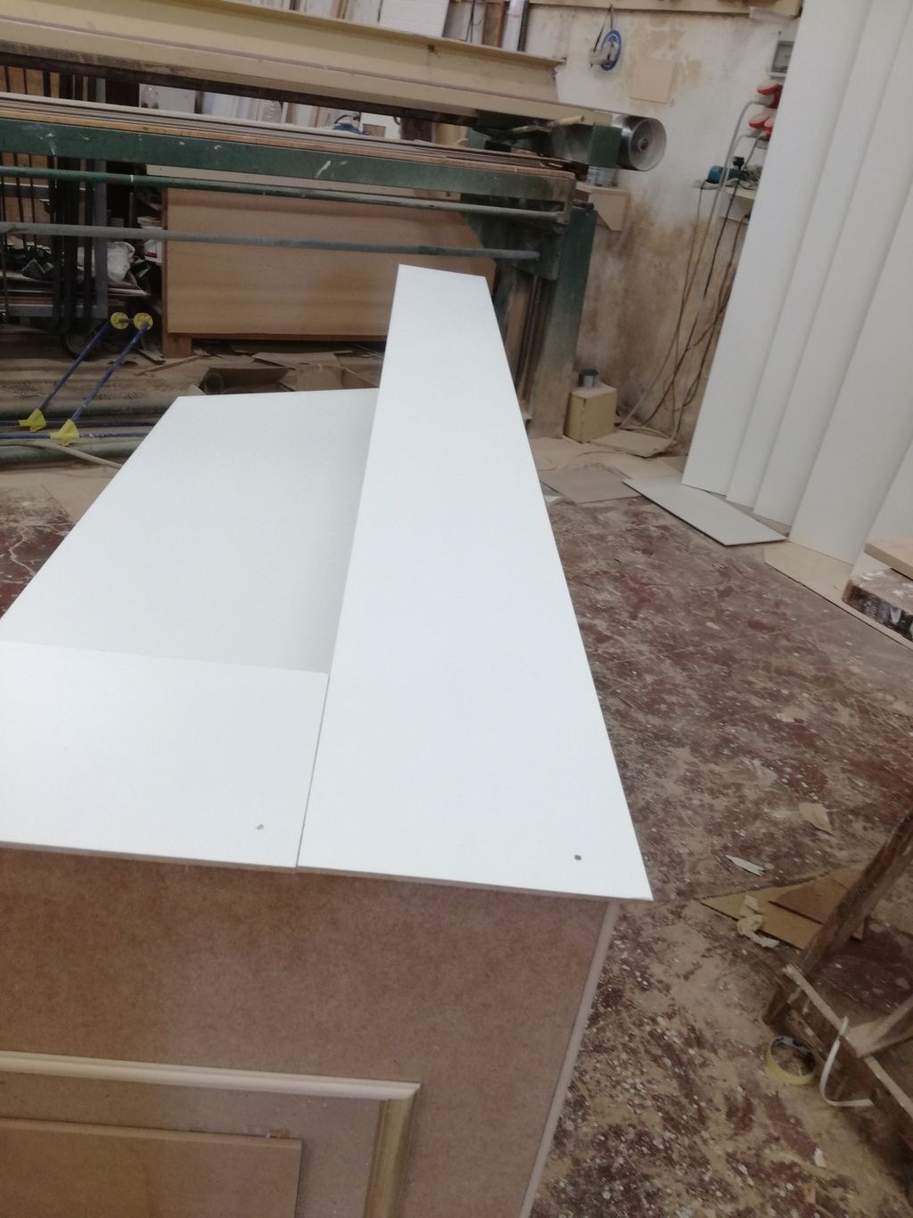 Pannelli di legno bianco in un armadio di un'officina, con un lungo pannello superiore sollevato.