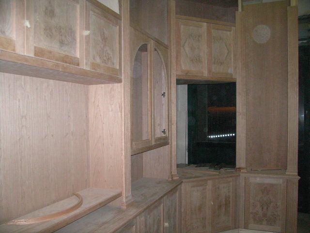 Armadi a muro bianchi integrati nel soffitto inclinato di una piccola camera da letto.
