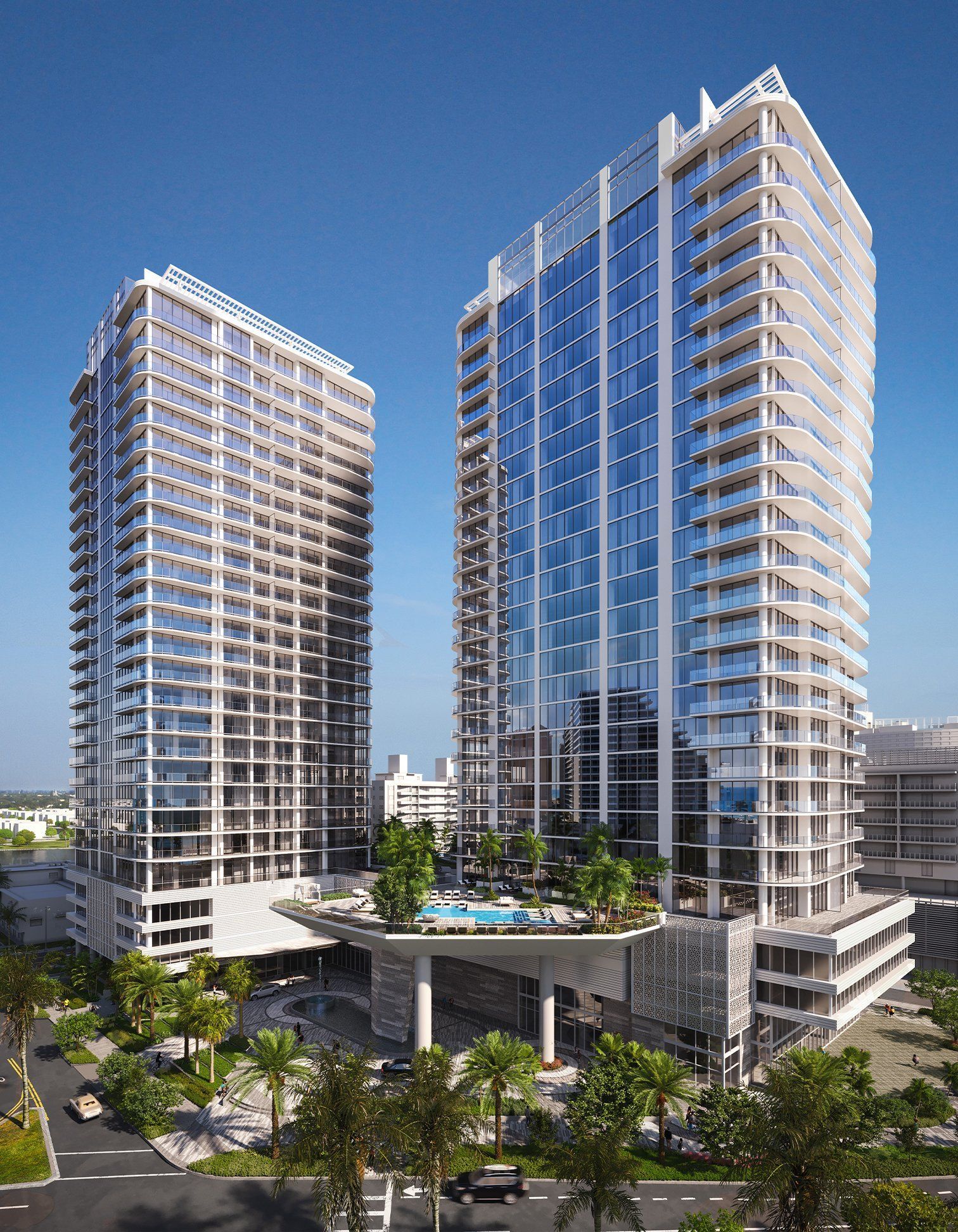Two modern glass high-rise towers with a pool deck under a clear blue sky