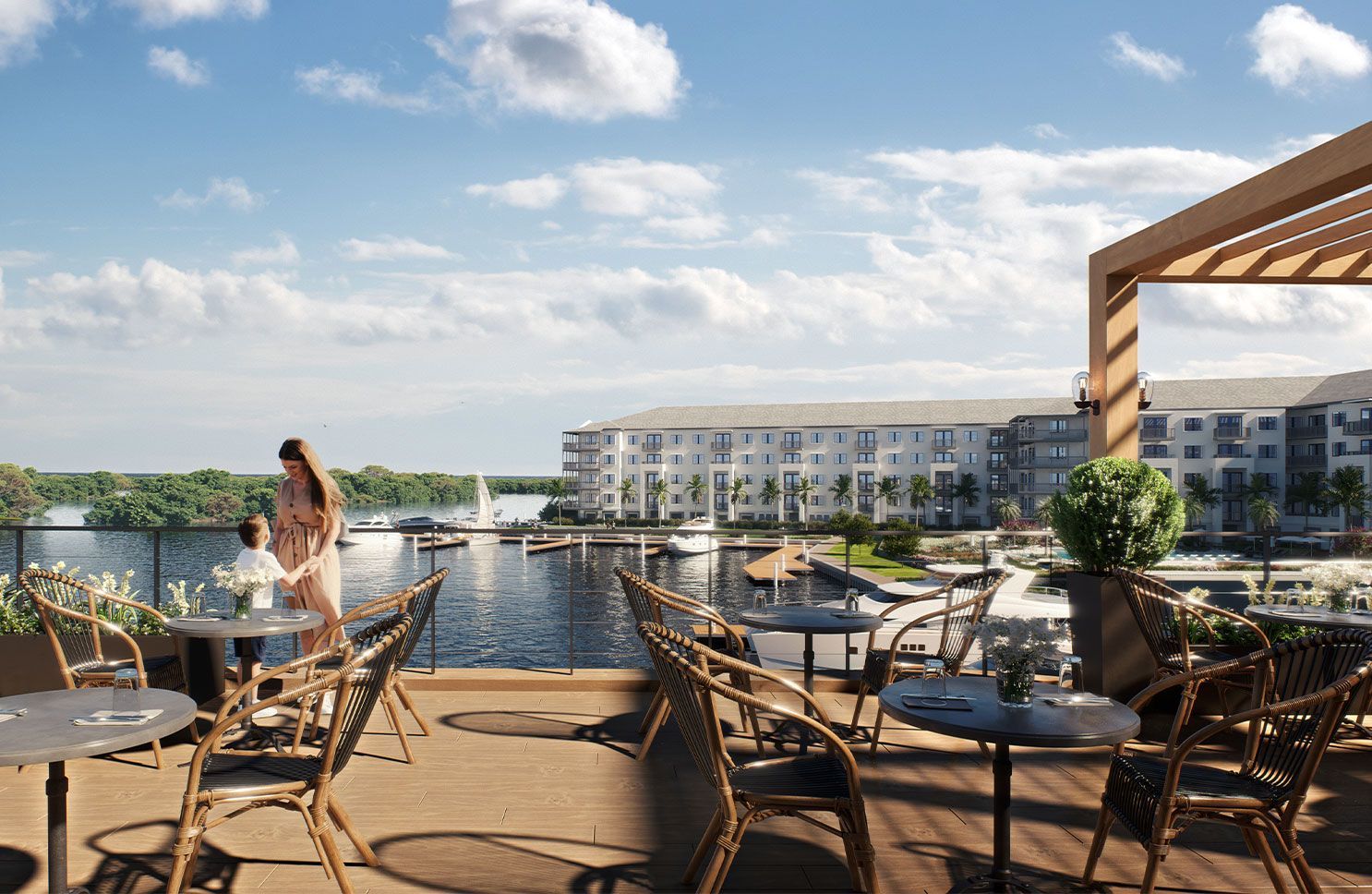 Rooftop terrace dining area overlooking a marina, with tables, chairs, and a person by the railing under a blue sky