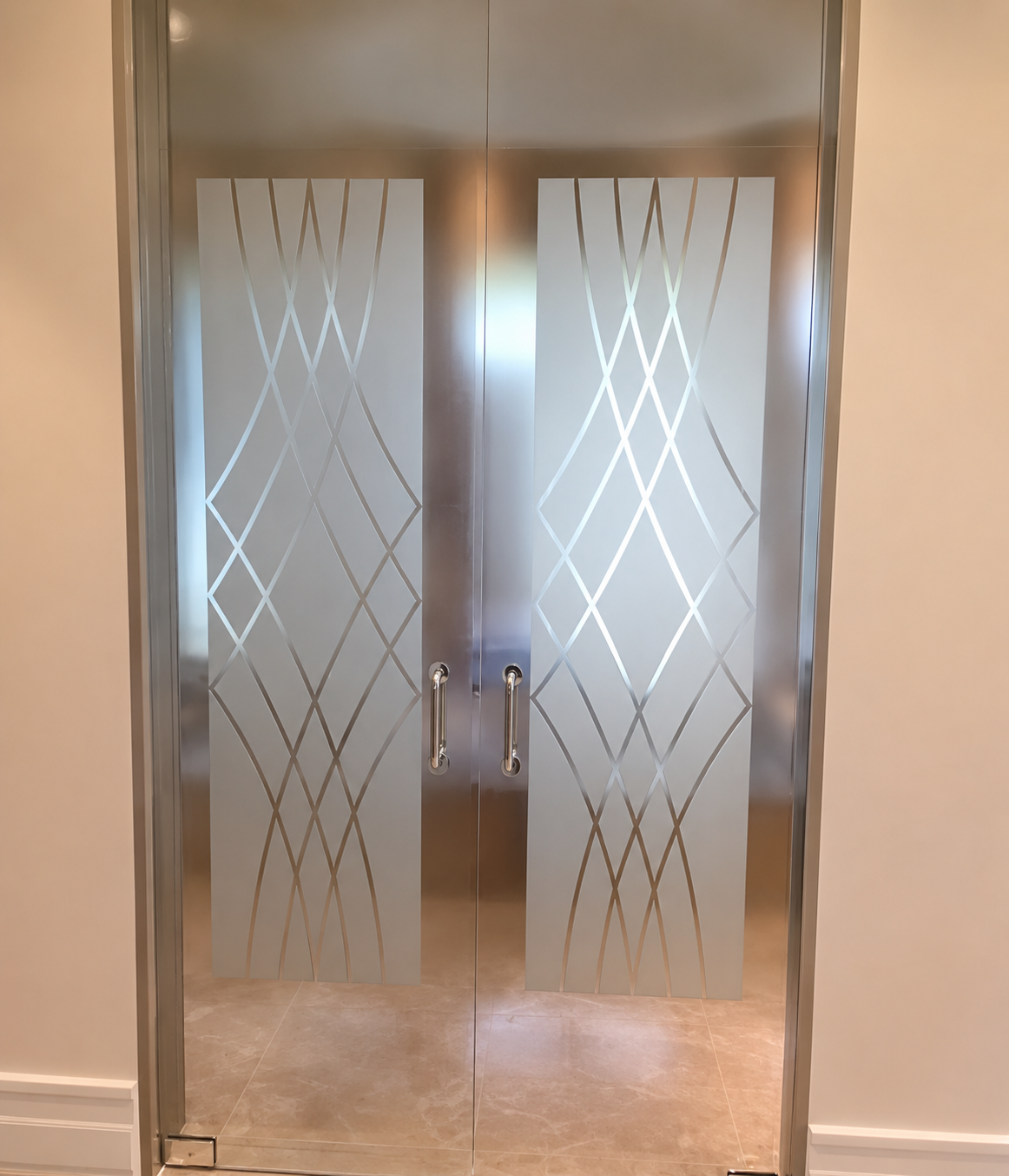 Glass double doors with frosted diamond patterns and metal handles in a hallway.