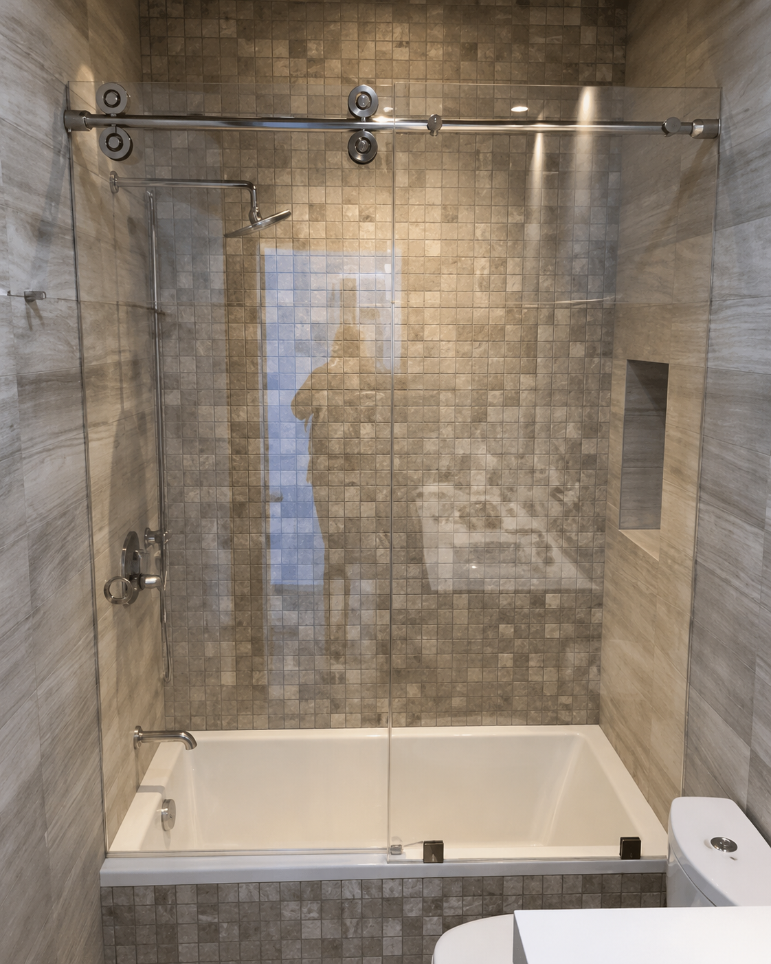 Glass-enclosed bathtub shower with stone tile walls and a rainfall showerhead