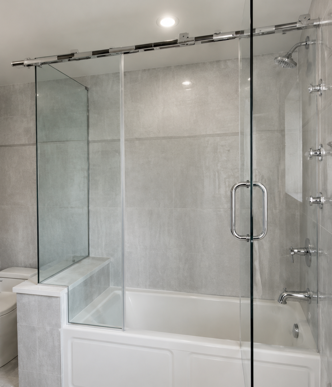Modern bathroom with a glass shower enclosure over a bathtub and built-in shelf.