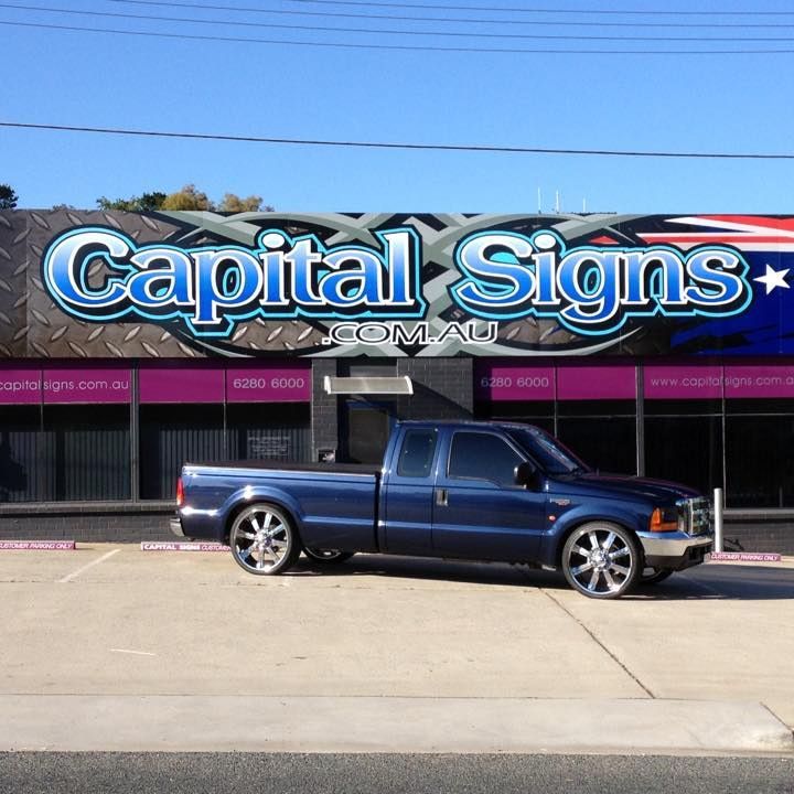 A Blue Truck Is Parked In Front Of A Building That Says Capital Signs — Capital Signs in Canberra, ACT