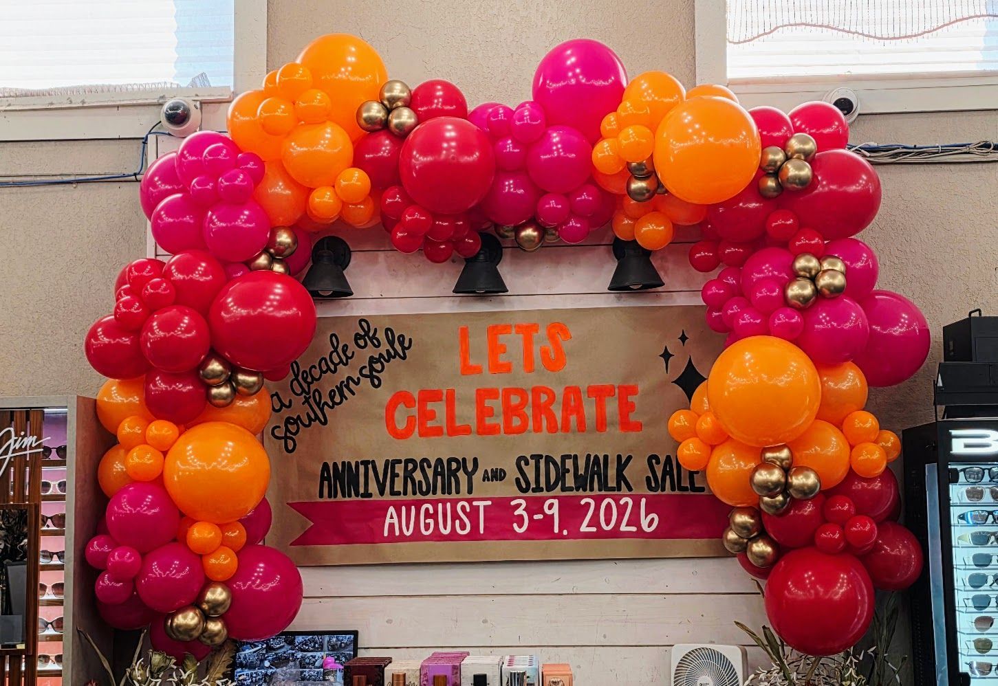 Bright pink orange and red custom organic balloon entrance arch rental for grand opening/anniversary event in San Antonio and Wilson County TX