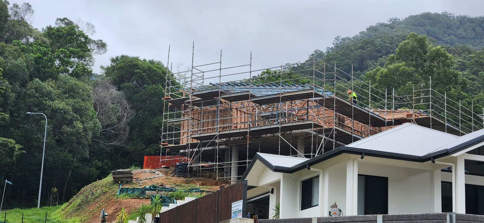 Two Construction Workers Wearing Safety Vests Inspect a Metal Scaffolding — Underdog Edge Protection in Redlynch, QLD