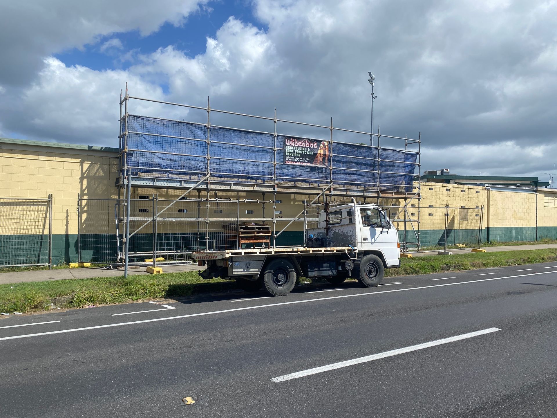 Person Spraying Red Coating on Corrugated Roof — Underdog Edge Protection in Redlynch, QLD