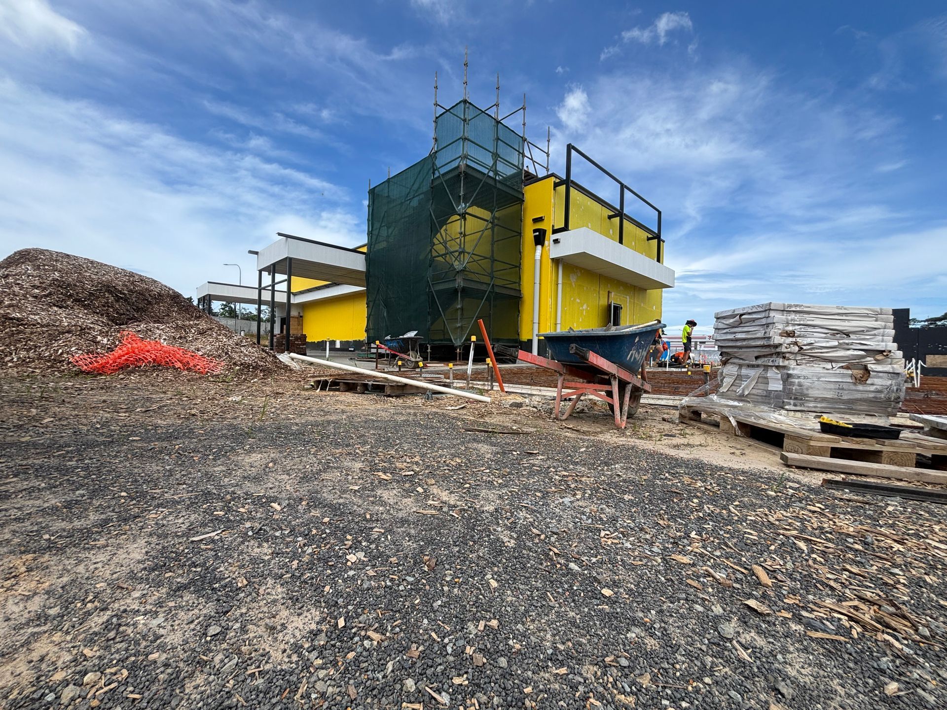 Yellow industrial machine at a gravel quarry with piles of rock and construction materials nearby — Underdog Edge Protection in Redlynch, QLD