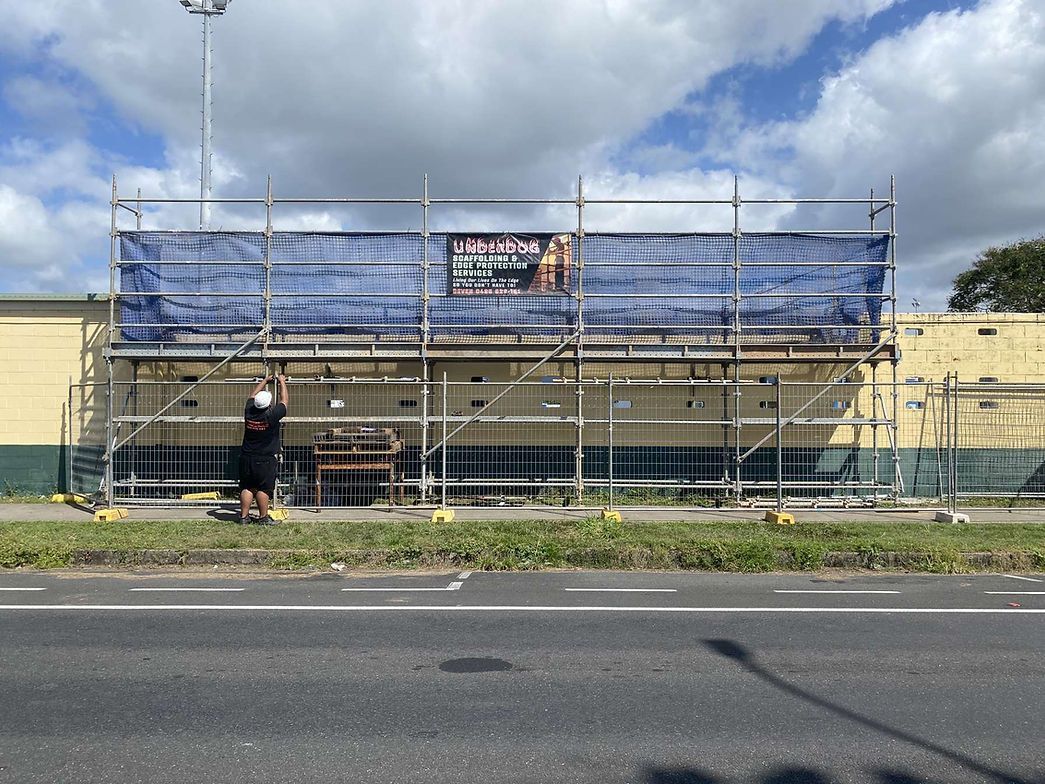 Construction Workers on Scaffolding Against a Blue Sky — Underdog Edge Protection in Redlynch, QLD