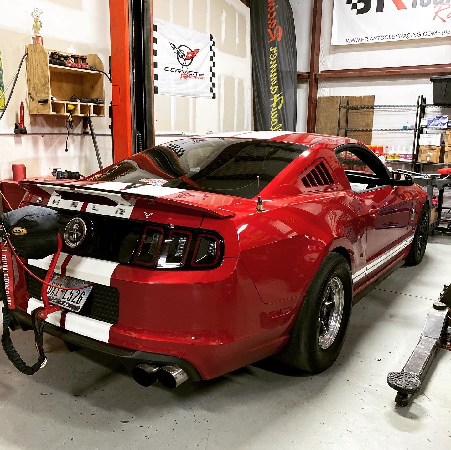 Red and white Mustang race car inside a garage. | YellowHammer Racing
