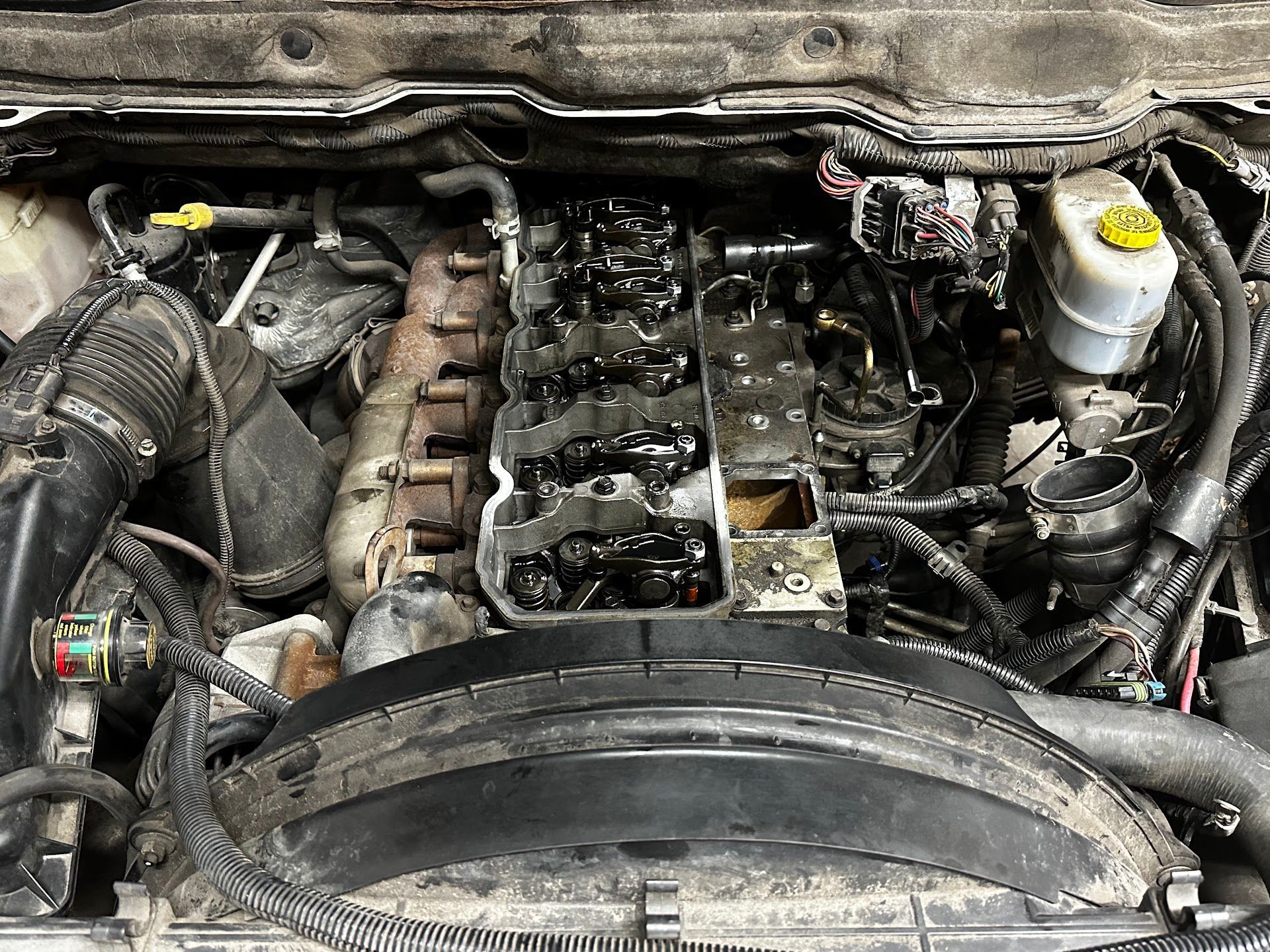 Open view of a dirty truck engine bay, exposing the engine's components. | YellowHammer Racing