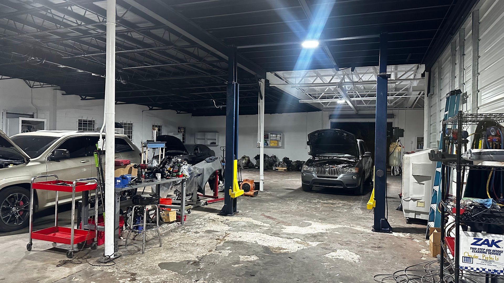 Auto repair shop interior with cars, tools, and a car lift. | YellowHammer Racing