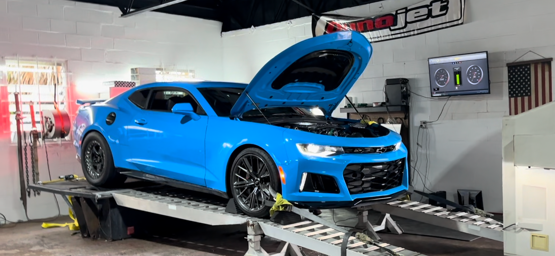 Blue Camaro on a dynamometer with hood open in a garage, dyno test in progress. | YellowHammer Racing