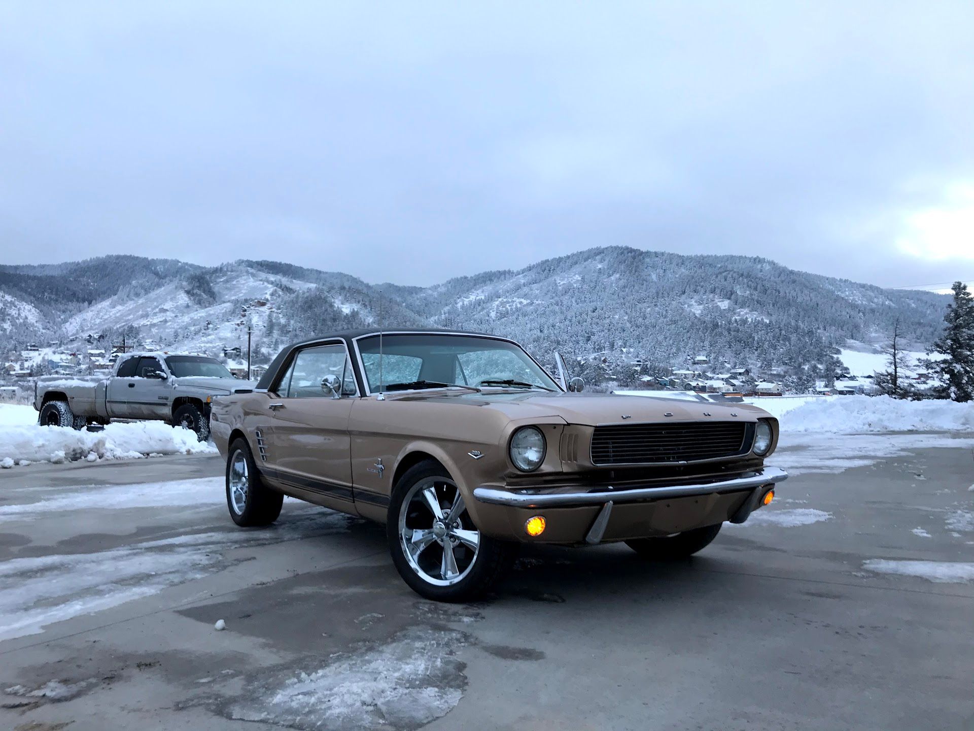 Tan vintage Ford Mustang convertible parked on a snowy day in front of mountains.  | YellowHammer Racing