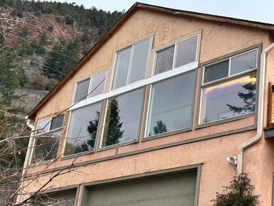 Modern house facade with large reflective windows on a mountainside