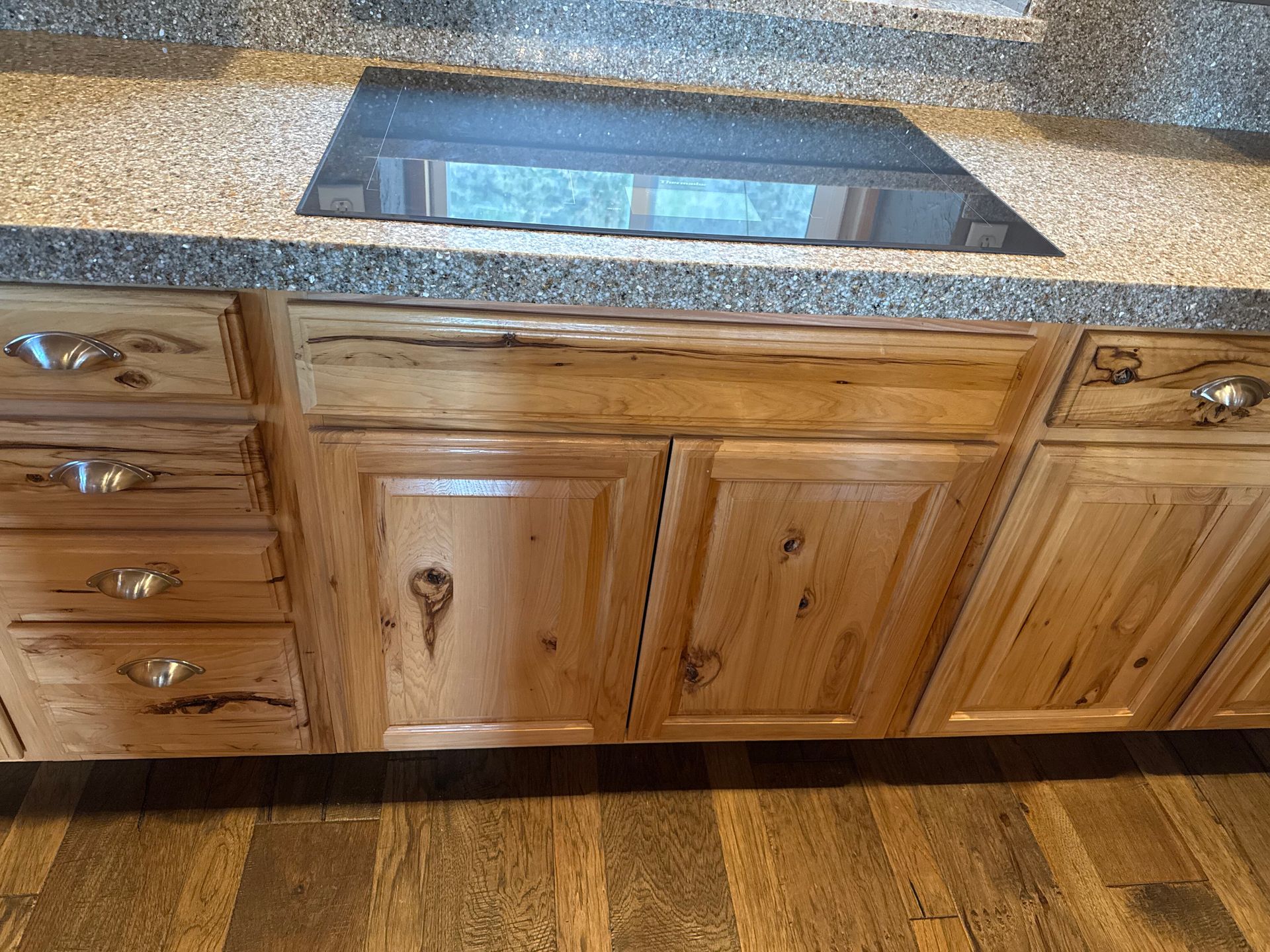 Kitchen countertop with built-in sink and wood cabinets over a wood floor