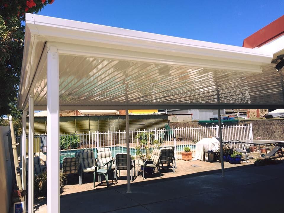 A white carport with a pool in the background