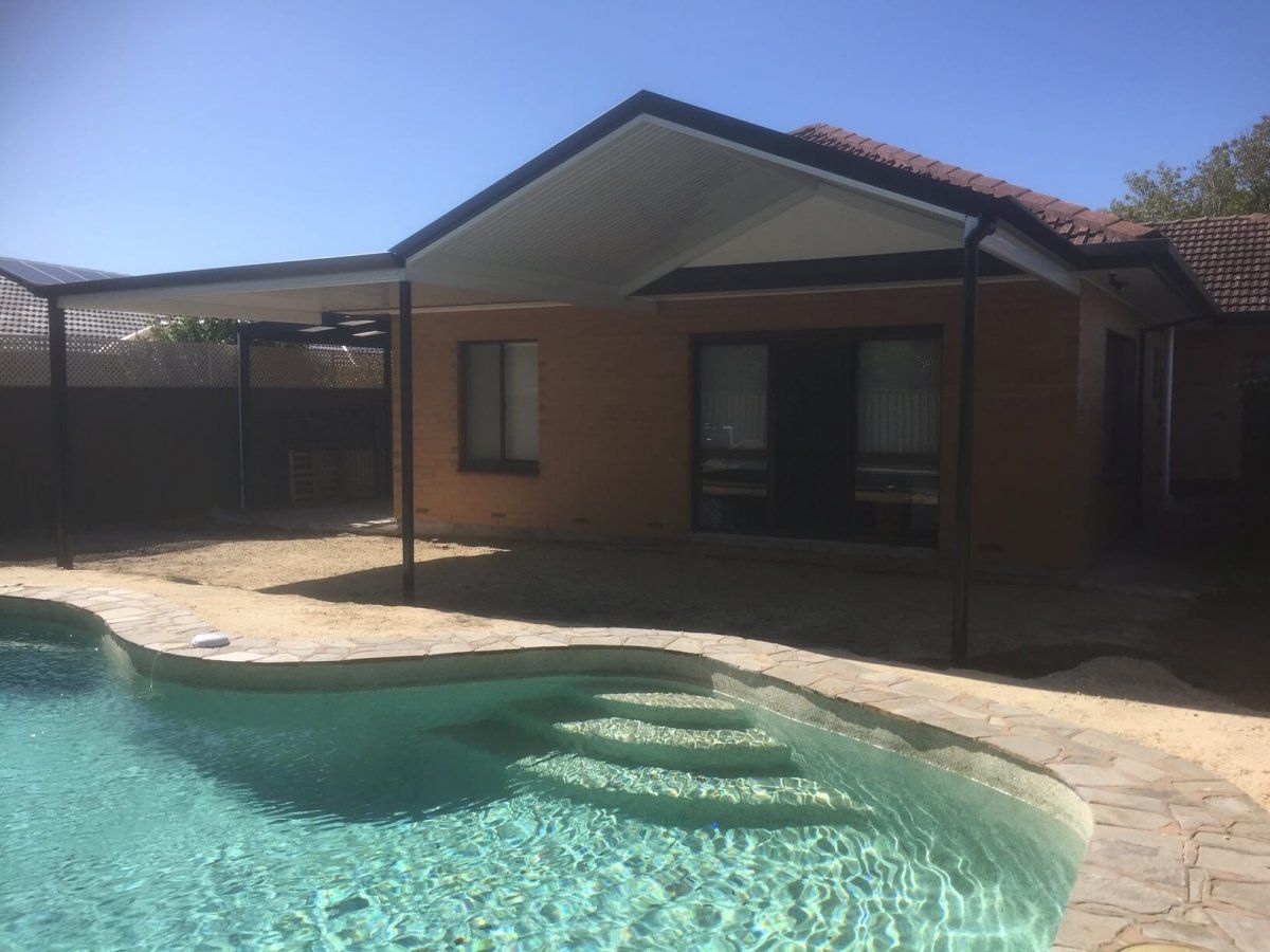 A house with a swimming pool in front of it.