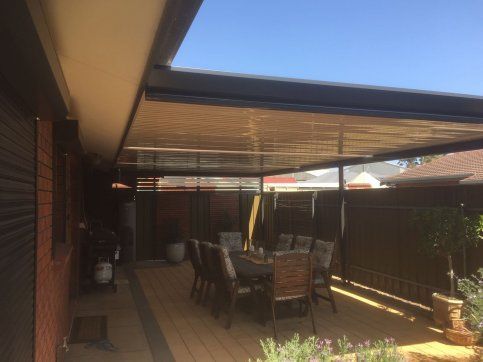 A patio with a table and chairs under a canopy.