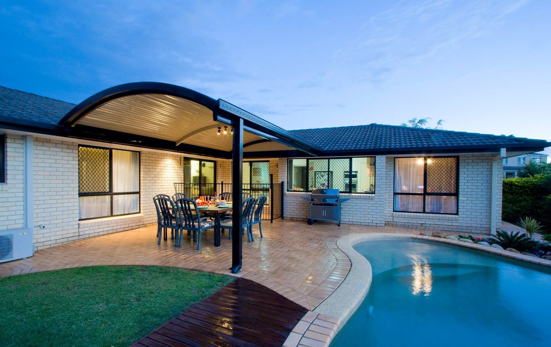 A house with a swimming pool and a patio with a table and chairs
