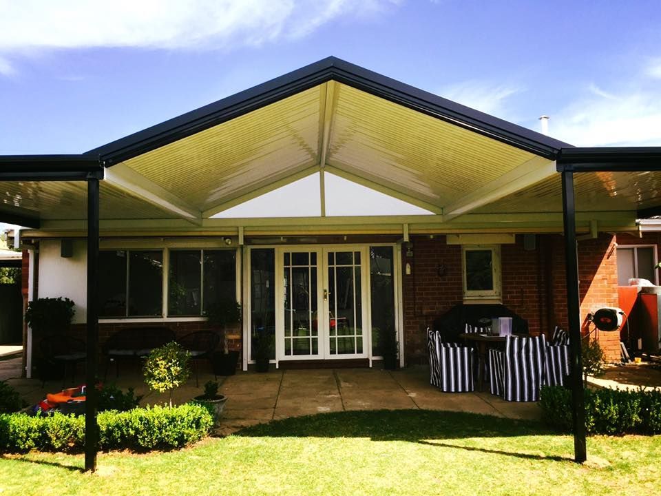 A house with a covered patio and a black roof