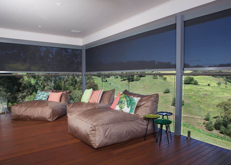 There are two bean bag chairs on the deck with a view of a field.