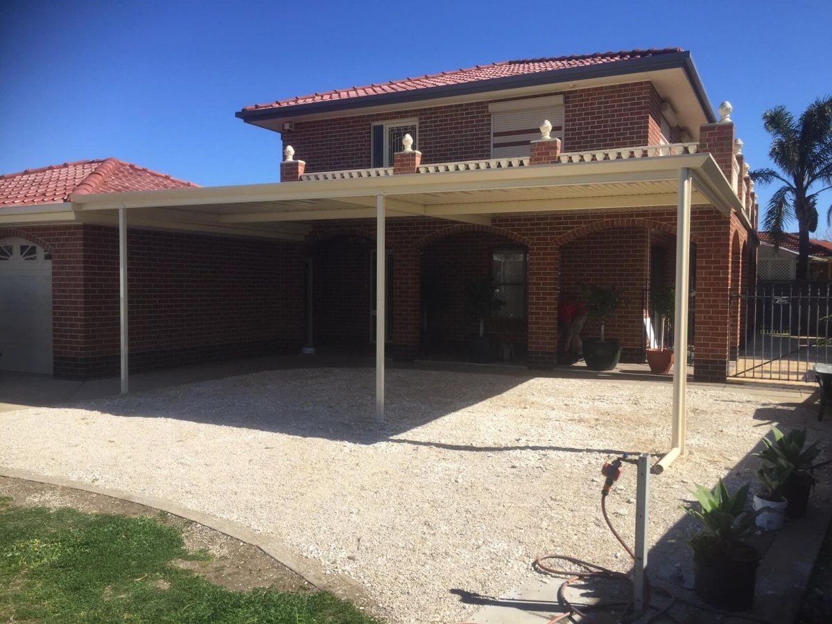 A brick house with a carport in front of it