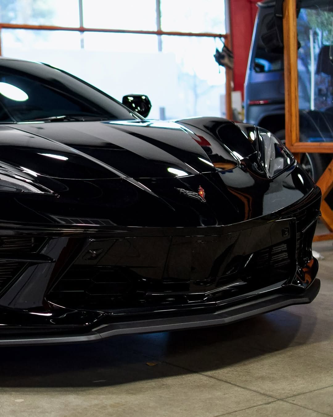 A black sports car is parked in a garage