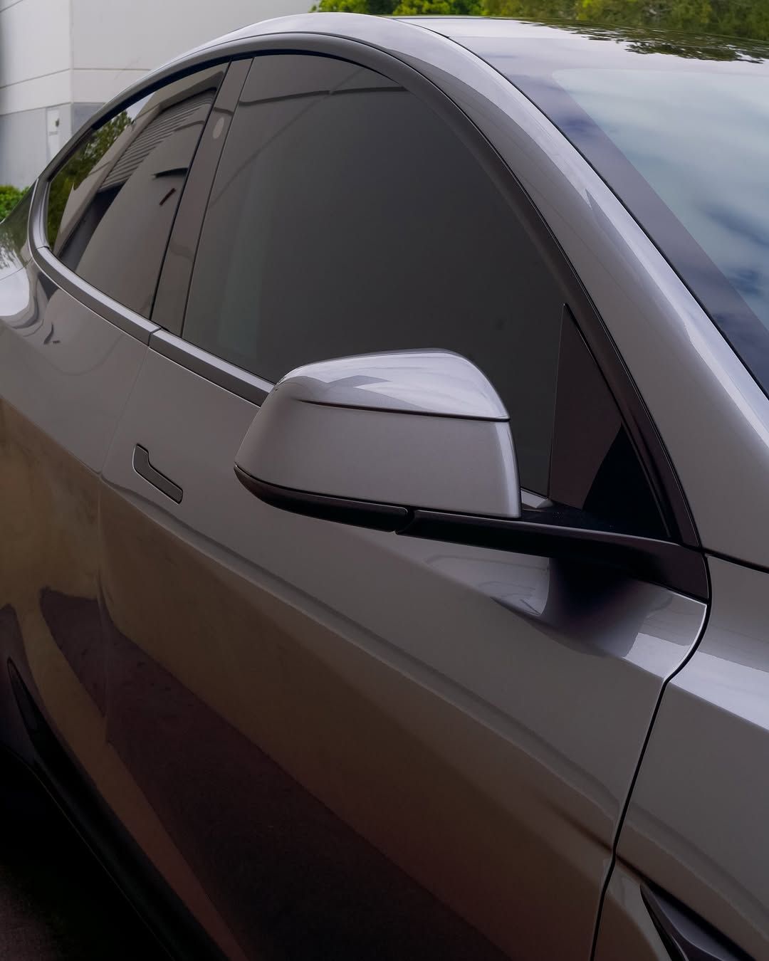 A silver car is parked in front of a building
