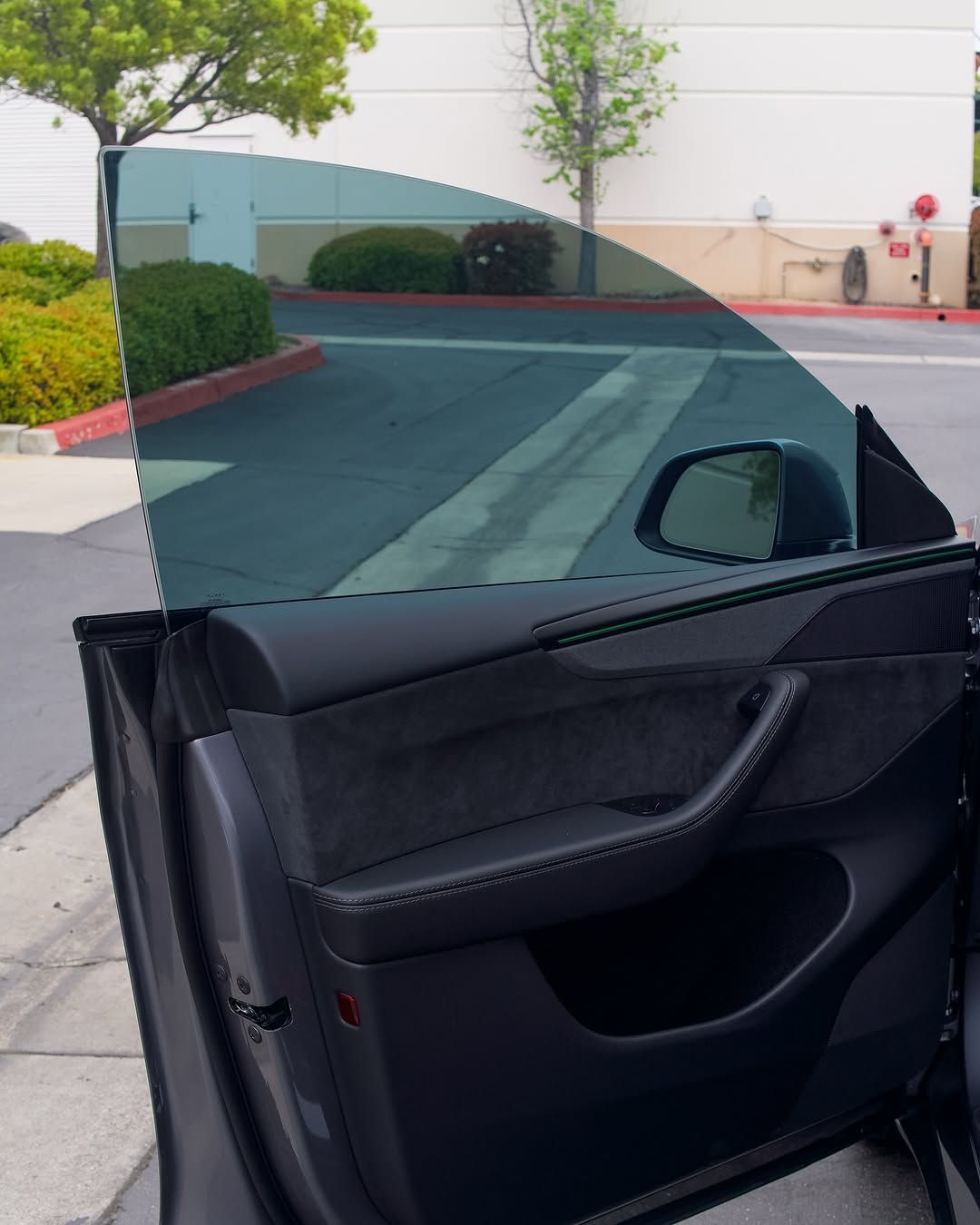 A car with the door open is parked in a parking lot